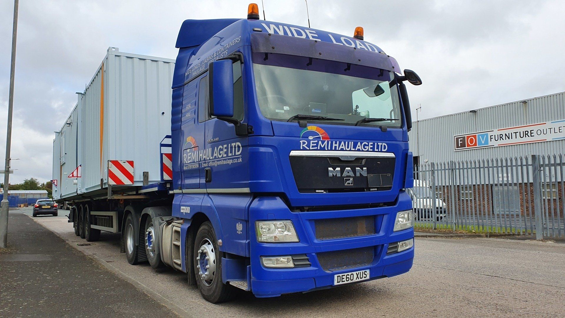 Blue Remi Haulage truck transporting a container