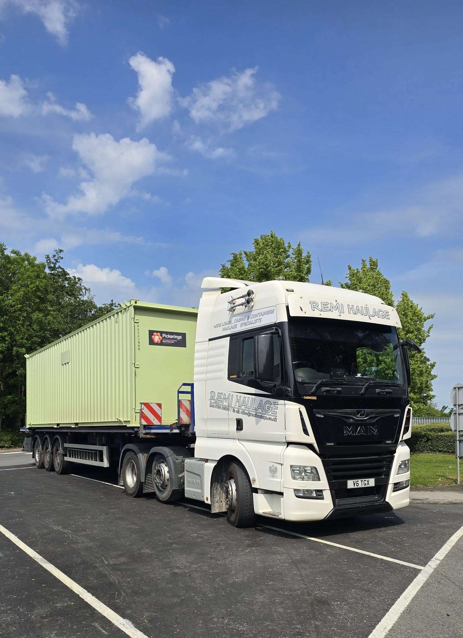 Remi Haulage MAN truck transporting a green portable cabin